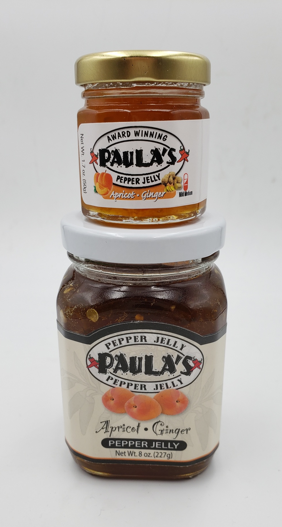 The 1.7 oz. pepper jelly jar on top of the 8 oz. pepper jelly jar from Paula’s Pepper Jelly.