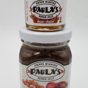 1.7 oz. organic jelly jar from Paula’s Pepper Jelly on top of an 8 oz. pepper jelly jar label-side out.
