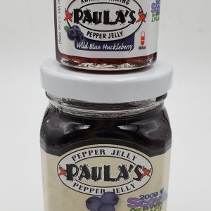 1.7 oz. wild blue huckleberry pepper jelly jar on top of the 8 oz. Paula’s Pepper Jelly jar. Both are full of Paula’s Wild Blue Huckleberry Pepper Jelly.