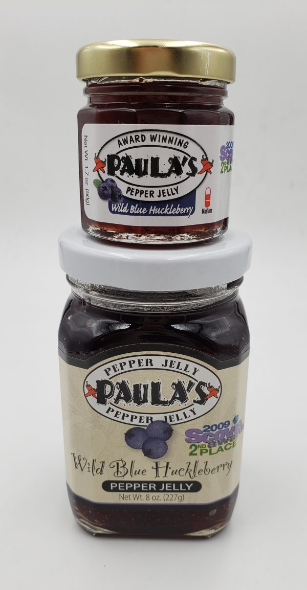 1.7 oz. wild blue huckleberry pepper jelly jar on top of the 8 oz. Paula’s Pepper Jelly jar. Both are full of Paula’s Wild Blue Huckleberry Pepper Jelly.